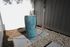 Elegant outdoor space featuring a modern blue ceramic fountain, surrounded by a white fence and stone tiles, creating a serene ambiance.