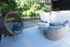 Charming outdoor patio featuring cozy wicker furniture, lush green surroundings, and serene garden views.