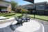 Inviting outdoor patio with cozy Adirondack chairs overlooking a beautifully landscaped mini-golf course, perfect for relaxation and leisure.