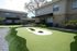 Charming apartment complex with a beautifully landscaped mini-golf area surrounded by cozy, well-maintained two-story buildings.