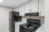 Modern kitchen with sleek black appliances, pristine white cabinetry, and elegant countertop design.