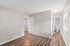 Bright, modern room with sleek wood flooring, neutral walls, and a cozy adjoining bathroom.