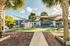 Charming outdoor space with palm trees and shade sails, perfect for relaxation and leisure.