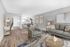 Elegant living room with hardwood floors, modern furniture, and an open dining area leading to a sleek kitchen.