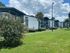 Charming apartment complex with manicured lawns, flowering shrubs, and modern exterior designs under a bright blue sky.