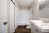 Modern bathroom with sleek fixtures, a spacious bathtub, elegant vanity, and wood-look flooring.