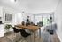 Bright and modern open-concept living room with stylish decor, featuring large windows, elegant furniture, and a cozy dining area.