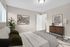 Inviting modern bedroom with contemporary decor, featuring elegant hardwood floors and artistic wall hangings.