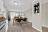 Chic dining area bathed in natural light with modern decor and wood floors in an airy open plan apartment.