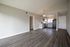 Bright open-plan apartment interior with sleek laminate flooring, modern kitchen appliances, and elegant lighting fixtures.