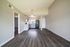 Bright open-concept apartment with modern kitchen and sleek laminate flooring.