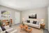 Bright and cozy living room featuring a modern beige sofa, stylish coffee tables, and elegant decor, perfect for relaxation and comfort.