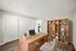 Inviting home office with elegant wooden desk and spacious bookshelves, perfect for productivity and organization.