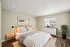 Inviting bedroom with modern decor, featuring a cozy bed, natural light, and stylish furnishings.
