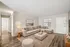 Inviting living room with a cozy beige sectional sofa, chic decor, and warm lighting on elegant wood flooring.