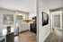 Charming apartment kitchen with white cabinets, modern appliances, and a cozy dining area bathed in natural light.