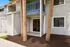 Charming apartment exterior with modern siding, inviting patio with tall palm trees, and a cozy balcony for relaxing outdoor living.