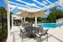 Inviting outdoor space with modern seating, BBQ grill, and sunlit swimming pool, perfect for relaxation.