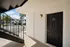 Inviting apartment entrance with modern black door and warm outdoor lighting, perfect for comfortable living.
