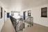 Modern apartment entrance featuring a sleek black door labeled G17, with stylish windows and elegant railing in a clean white hallway.