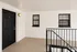 Modern apartment entrance featuring a sleek black door labeled G17, with stylish windows and elegant railing in a clean white hallway.