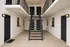 Modern apartment entry with sleek black doors, elegant stairway, and contemporary lighting.