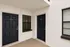 Modern apartment entryway with elegant dark doors and stylish windows, offering a welcoming and sophisticated ambiance.