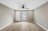 Bright modern room with elegant wood flooring, neutral walls, and a sleek ceiling fan, inviting and move-in ready.