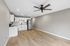 Modern open-concept apartment featuring a sleek kitchen with white cabinetry, stainless steel appliances, and elegant hardwood floors.