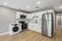 Modern kitchen with sleek stainless steel appliances, white cabinetry, and stylish wood flooring for a chic and functional design.