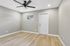 Bright, modern room with sleek wood flooring, neutral walls, and elegant ceiling fan, perfect for customization.