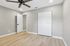 Spacious bedroom with modern ceiling fan, elegant wood floors, and ample closet space in a chic apartment.