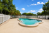 Inviting outdoor pool surrounded by lush greenery and comfortable lounge chairs, perfect for relaxation.
