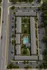 Aerial view of a modern apartment complex featuring a central pool, lush green landscaping, and ample parking spaces. Situated at the intersection of N Armenia Ave and W Diana St for convenient urban living.