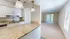 Elegant apartment interior featuring a modern kitchen with granite countertops and an inviting living room with large windows.