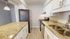 Modern kitchen with elegant granite countertops, stainless steel appliances, and sleek white cabinetry.