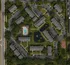 Bird's-eye view of a charming apartment complex featuring lush greenery, a refreshing pool area, and serene pond with fountain, complemented by ample parking and a playground.