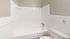 Bright and modern bathroom featuring a sleek white bathtub, tiled walls, and a convenient showerhead for a refreshing experience.