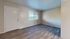 Bright and inviting apartment living area with sleek hardwood flooring, large window, and neutral wall colors, offering a spacious and welcoming ambiance.