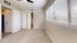 Bright bedroom with large windows, plush carpet, and spacious closet, perfect for cozy living.