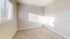 Sunlit bedroom with soft carpet flooring and neutral walls, creating a cozy and inviting atmosphere.