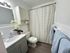 Inviting bathroom with elegant vanity, decorative orchids, and cozy blue towels, offering a serene oasis.