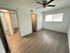 Bright, airy bedroom with sleek wooden flooring, modern ceiling fan, and generous closet space.