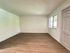 Bright, airy living room with elegant wood flooring and large window offering natural light.