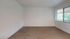 Bright and inviting room with elegant wood flooring and large window offering scenic views, perfect for a cozy lounge or creative workspace.