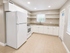 Bright and spacious modern kitchen with elegant white cabinetry, granite countertops, and built-in shelving.