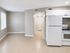 Bright and airy apartment kitchen showcasing modern white cabinetry, spacious tiled flooring, and natural light for a cozy living experience.