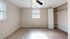 Bright and airy bedroom with elegant hardwood floors, ceiling fan, open closet, and charming window view.