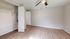 Bright and airy empty room with sleek wooden flooring, open closet space, and modern ceiling fan, ideal for customization and personal style.