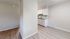 Modern apartment scene showcasing a sleek kitchen with bright cabinetry and elegant wood flooring.